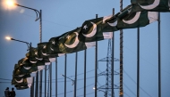 Capital Development Authority (CDA) workers set up Pakistan's national flags along a street in Islamabad on April 18, 2026. 

Photo by Farooq NAEEM / AFP