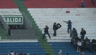 Fans of Cerro Porteno clash with police officers during the Paraguayan tournament football match between Olimpia and Cerro Porteno at the Defensores del Chaco stadium in Asuncion on April 19, 2026. (Photo by Daniel Duarte / AFP)