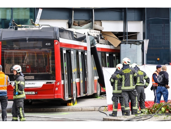 Firefighters and rescue personnel stand next to a trolleybus that crashed into a supermarket on April 20, 2026 in Salzburg, Austria. (Photo by various sources / AFP) 