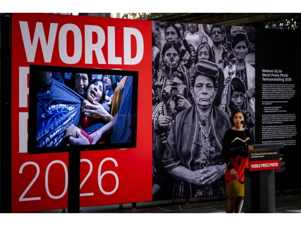 World Press Photo executive director Joumana El Zein Khoury announces the winner of the World Press Photo of the Year 2026, US photographer Carol Guzy (her winning photograph shown on left), during the 2026 World Press Photo Awards ceremony, in Amsterdam on April 23, 2026. (Photo by Robin van Lonkhuijsen / ANP / AFP) 