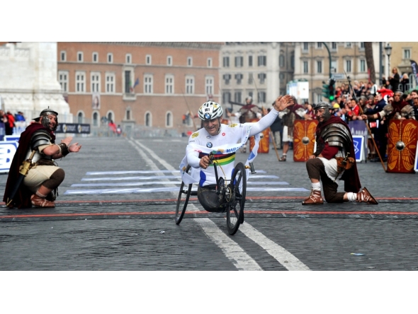(Files) Former driver and paracyclist Alex Zanardi celebrates as he crosses the fininsh line of the 20th Marathon of Rome on March 23, 2014. (Photo by Tiziana Fabi / AFP)