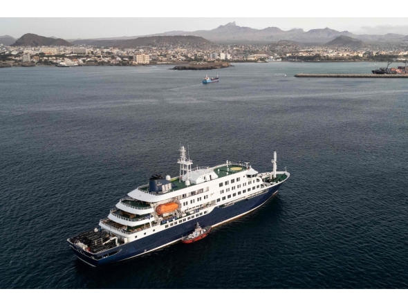 This aerial view shows health personnel boarding the cruise ship MV Hondius, while stationary off the port of Praia, the capital of Cape Verde, on May 6, 2026. Photo by AFP