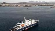 This aerial view shows health personnel boarding the cruise ship MV Hondius, while stationary off the port of Praia, the capital of Cape Verde, on May 6, 2026. Photo by AFP