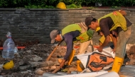 A road construction crew works at dusk in Jakarta on May 6, 2026. (Photo by BAY ISMOYO / AFP)