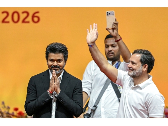 Newly elected chief minister of India's Tamil Nadu state, C. Joseph Vijay (L) along with Indian National Congress (INC) party leader Rahul Gandhi (R) greets supporters after taking the oath during his swearing-in ceremony in Chennai on May 10, 2026. (Photo by R.Satish BABU / AFP)