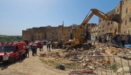 Rescuers search through the rubble of a four-storey building that collapsed overnight in the Moroccan city of Fes, on May 21, 2026. (Photo by Abdelmajid Bziouat / AFP)
