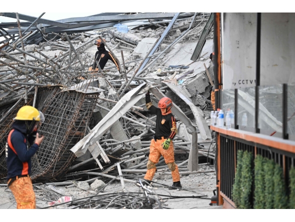 Rescuers remove metal rubbles as they search for survivors on a collapsed building in Angeles City, Pampanga province, north of Manila on May 24, 2026. Nineteen people are feared trapped after a building under construction near Manila collapsed early on May 24, a local government official said. (Photo by Ted ALJIBE / AFP)