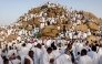 Muslim pilgrims pray at dawn on Saudi Arabia's Mount Arafat, also known as Jabal al-Rahma or Mount of Mercy, during the climax of the Hajj pilgrimage on May 26, 2026. (Photo by Zain JAAFAR / AFP)