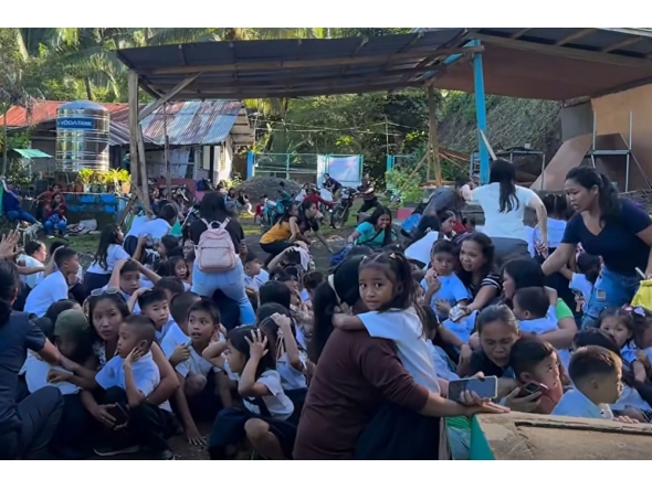 This frame grab made from UGC video footage courtesy of Deped Mahayahay Elementary School shows huddled schoolchildren in a field reacting during an 7.8 magnitude earthquake in Malita town, Davao del Sur province on June 8, 2026. (Photo by Courtesy of Deped Mahayahay Elementary School / AFP) 