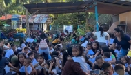 This frame grab made from UGC video footage courtesy of Deped Mahayahay Elementary School shows huddled schoolchildren in a field reacting during an 7.8 magnitude earthquake in Malita town, Davao del Sur province on June 8, 2026. (Photo by Courtesy of Deped Mahayahay Elementary School / AFP) 