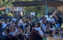 This frame grab made from UGC video footage courtesy of Deped Mahayahay Elementary School shows huddled schoolchildren in a field reacting during an 7.8 magnitude earthquake in Malita town, Davao del Sur province on June 8, 2026. (Photo by Courtesy of Deped Mahayahay Elementary School / AFP) 