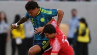 Richard Rios of Colombia fights for the ball with Mohammad Abualnadi of Jordan.