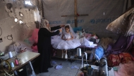 A Palestinian girl tries on a dress to wear at a wedding celebration in the city of Khan Yunis in the southern Gaza Strip on June 13, 2026. (Photo by Bashar Taleb / AFP) 