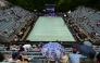 The court is covered and spectators use umbrellas as rain started after the first women's singles semi-final match at the WTA500 Berlin Tennis Open tournament in Berlin on June 20, 2026. (Photo by John MacDougall / AFP)