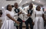 Grooms and brides dance during their wedding ceremony at the Bishop Akinyele Memorial Anglican Church in Ibadan, on June 20, 2026. (Photo by OLYMPIA DE MAISMONT / AFP)