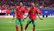 Gessime Yassine #16 of Morocco celebrates with teammate Achraf Hakimi #2 after scoring his team's fourth goal on June 24, 2026 in Atlanta, Georgia. Kevin C. Cox/Getty Images/AFP