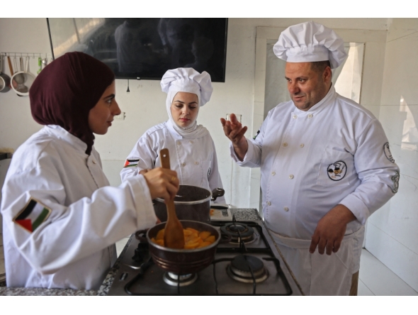 Palestinian youth learn the basics of cooking at the Smile Kitchen Academy, in the Rimal neighborhood of Gaza City on June 24, 2026. (Photo by Omar Al-Qattaa / AFP)