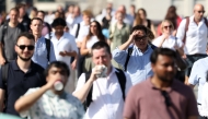Commuters walk in the sun as they cross London Bridge, during a heatwave, in central London on June 24, 2026. (Photo by Toby Shepheard / AFP)