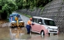 A tow lorry driver retrieves a partially submerged car after flooding in the town of Kashiwara, Osaka prefecture on June 26, 2026.  (Photo by Paul Miller/ AFP)