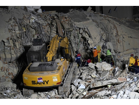 Rescue teams operate heavy machinery at the site of a collapsed building in Caracas on June 25, 2026, following earthquakes. (Photo by Juan BARRETO / AFP)