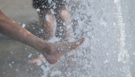 People cool off with the water of a fountain in Berlin on June 28, 2026. (Photo by Ralf Hirschberger / AFP)