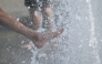 People cool off with the water of a fountain in Berlin on June 28, 2026. (Photo by Ralf Hirschberger / AFP)