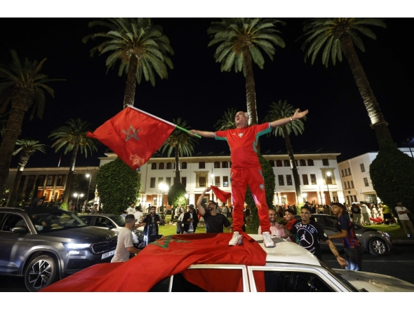 A man waves the Moroccan national flag as football fans celebrate Morocco's victory over the Netherlands in the Round of 32 of the 2026 World Cup, in Rabat early on June 30, 2026. (Photo by Abdel Majid Bziouat / AFP)
 