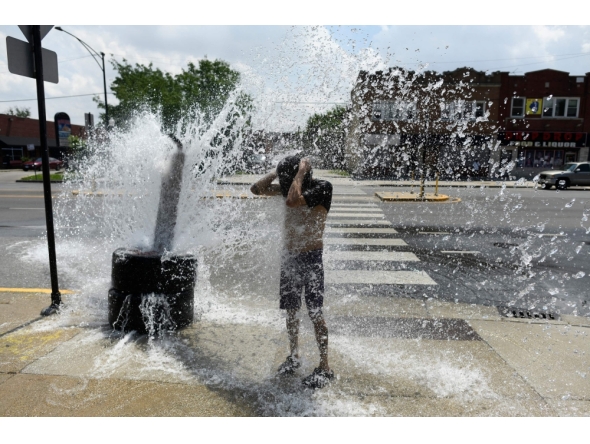 A person cools off with water from an open fire hydrant during a heat wave on the West Side of Chicago, Illinois, on July 2, 2026. (Photo by Octavio Jones / AFP)