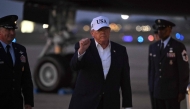 US President Donald Trump gestures toward reporters after disembarking from Air Force One at Joint Base Andrews, Maryland on July 1, 2026. (Photo by Saul Loeb / AFP)