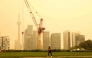 A person walks by the skyline of downtown Toronto, as smoke from forest fires in Northern Ontario causes poor air quality over the city, in Toronto, Ontario, Canada, Wednesday, July 15, 2026. (Photo by Cole BURSTON / AFP)