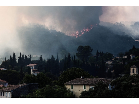 Flames spread on the hills surrounding Cotignac, southeastern France on July 23, 2026 during a wildfire. (Photo by Thibaud MORITZ / AFP)