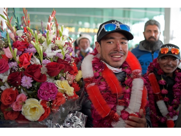(Files) Nepal's climber Nirmal Purja (C) watches upon his arrival along with his team at the airport in Islamabad on January 21, 2021. (Photo by Farooq Naeem / AFP)