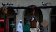 Pigeons cool off at a decorative water fountain in Doha on July 25, 2026. (Photo by KARIM JAAFAR / AFP)