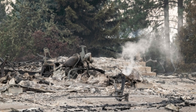 A burned motorcycle sits in the ashes of burned out residential home in the Balboa neighborhood of Spokane, Washington, on August 2, 2026. (Photo by Erick Doxey / AFP)
 
