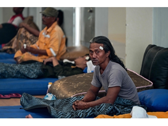 Survivors of the ferry fire recover at Tanjung Perak port in Surabaya on August 3, 2026, a day after the disaster that killed at least five people and prompted many to jump from the vessel into the sea. (Photo by JUNI KRISWANTO / AFP)