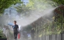 Pedestrians walk along a mist-spraying zone to cool off on a street in Seoul on August 3, 2026, as a scorching heat wave continues to grip South Korea. (Photo by Jung Yeon-je / AFP)