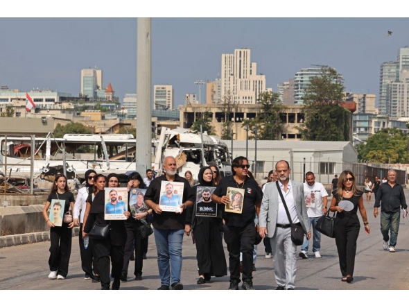 Family members march while carrying the portraits of the victims of 2020 Beirut port blast near the blast's ground zero on the sixth anniversary of the explosion, in Beirut on August 4, 2026. Photo by Anwar AMRO / AFP