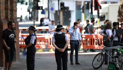 Police community support officers (PCSOs) stand behind cordon tape at Endell road in covent garden, central London on August 5, 2026. Photo by Henry NICHOLLS / AFP