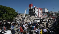 People look for survivors amid the rubble of a collapsed building after an earthquake in Cali, Colombia on August 10, 2026. (Photo by JOAQUIN SARMIENTO / AFP)
