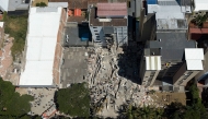 This aerial view shows rescuers searching for survivors amid the rubble of a collapsed building after an earthquake in Cali, Colombia on August 11, 2026. (Photo by JOAQUIN SARMIENTO / AFP)