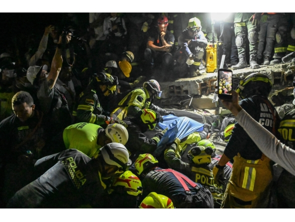 Firefighters and rescue teams carry survivor Daniela Andrea Largo Sanchez out of the rubble of a collapsed building after an earthquake in Pereira, Colombia on August 11, 2026.  (Photo by David SALAZAR / AFP)