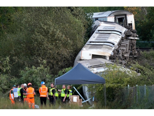 Carriages of a derailed train are pictured on their side, near the town of Lewes, southern England on August 13, 2026. Two people sustained 