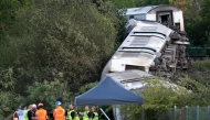 Carriages of a derailed train are pictured on their side, near the town of Lewes, southern England on August 13, 2026. Two people sustained 