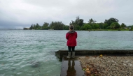 A resident looks at a young green sea turtle as ocean waters started to raise due to the approach of Tropical Storm Lala at Reed's Bay in Hilo, Hawaii on August 14, 2026. (Photo by Jill K. Briggs / AFP)
 