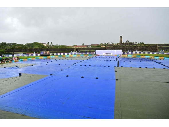 A general view shows covered ground as rain delays the start of play on second day of the first Test cricket match between Sri Lanka and India at the Galle International Stadium in Galle on August 16, 2026. (Photo by Ishara S. KODIKARA / AFP)