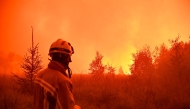 This handout photograph taken on August 15, 2026 and released on August 17, 2026 by VHP shows a firefighter looking at wildfire in the Hautes Fagnes (High Fens) nature reserve. Photo by HANDOUT / VHP / AFP