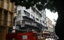 Onlookers and fire personnel gather at the site following a fire at a hotel in Kolkata on August 19, 2026. Photo by Dibyangshu SARKAR / AFP