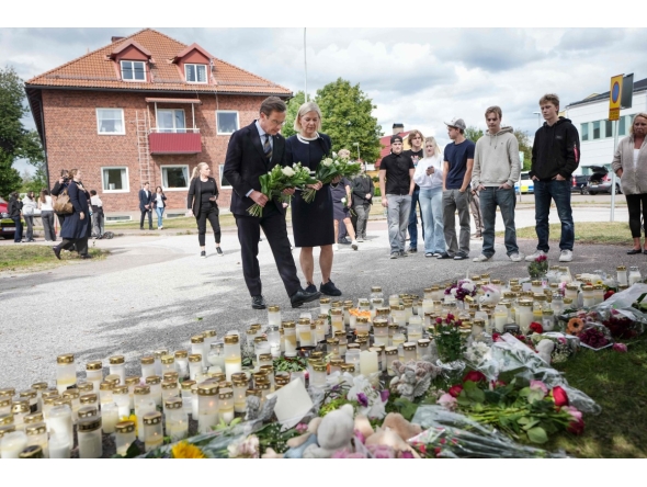Swedish Prime Minister Ulf Kristersson and Social Democratic Party leader Magdalena Andersson visit the makeshift memorial outside a school in Fagersta, central Sweden, on August 22, 2026, a day after a 17-year-old girl was killed and three other people were injured in a sword attack at the school. Photo by Magnus LEJHALL / TT NEWS AGENCY / AFP