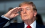 US President Donald Trump salutes during the national anthem at the start of the race, during the Freedom 250 Grand Prix Race on the streets of Washington, DC, on August 23, 2026.(Photo by Doug MILLS / AFP)