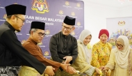 Ambassador of Malaysia H E Faizal Razali with officials and community members cutting the cake.